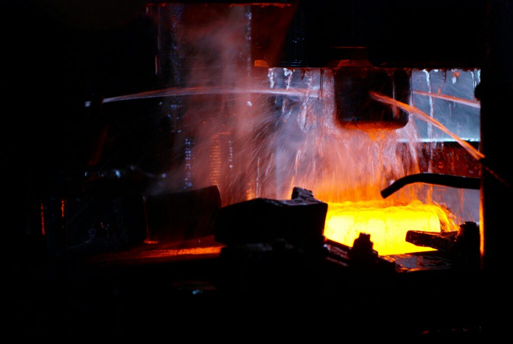 metal forging. hydraulic hammer shapes the red hot billet. the production of high tech parts