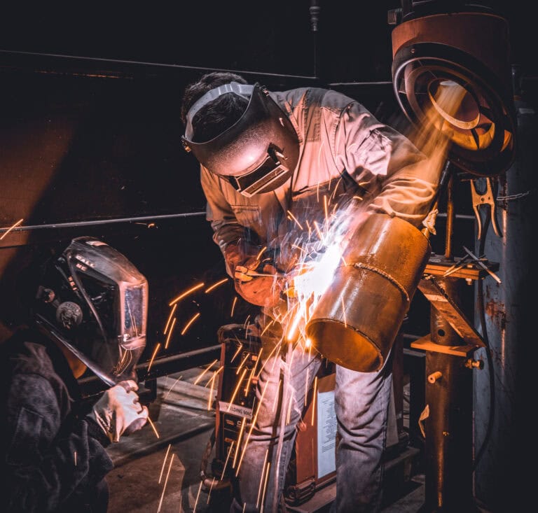 Engineers welding metal sections. CTOD testing has an important purpose in critical weld sections.