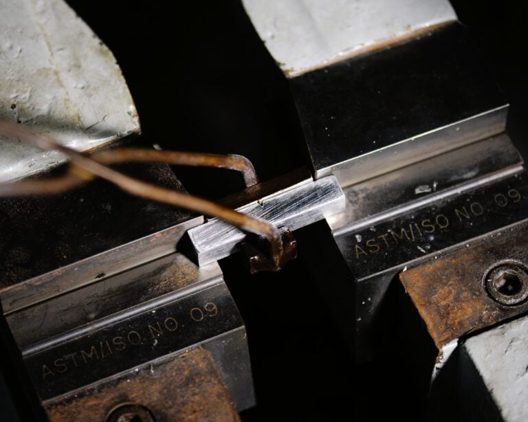 A Charpy impact test set up for a steel V-notch specimen seated in the ASTM/ISO test anvil.