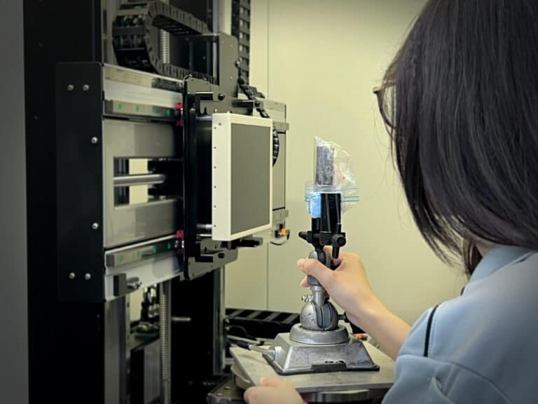 A PTS engineer with micro-CT scanning setup for non-destructive failure analysis of internal defects.