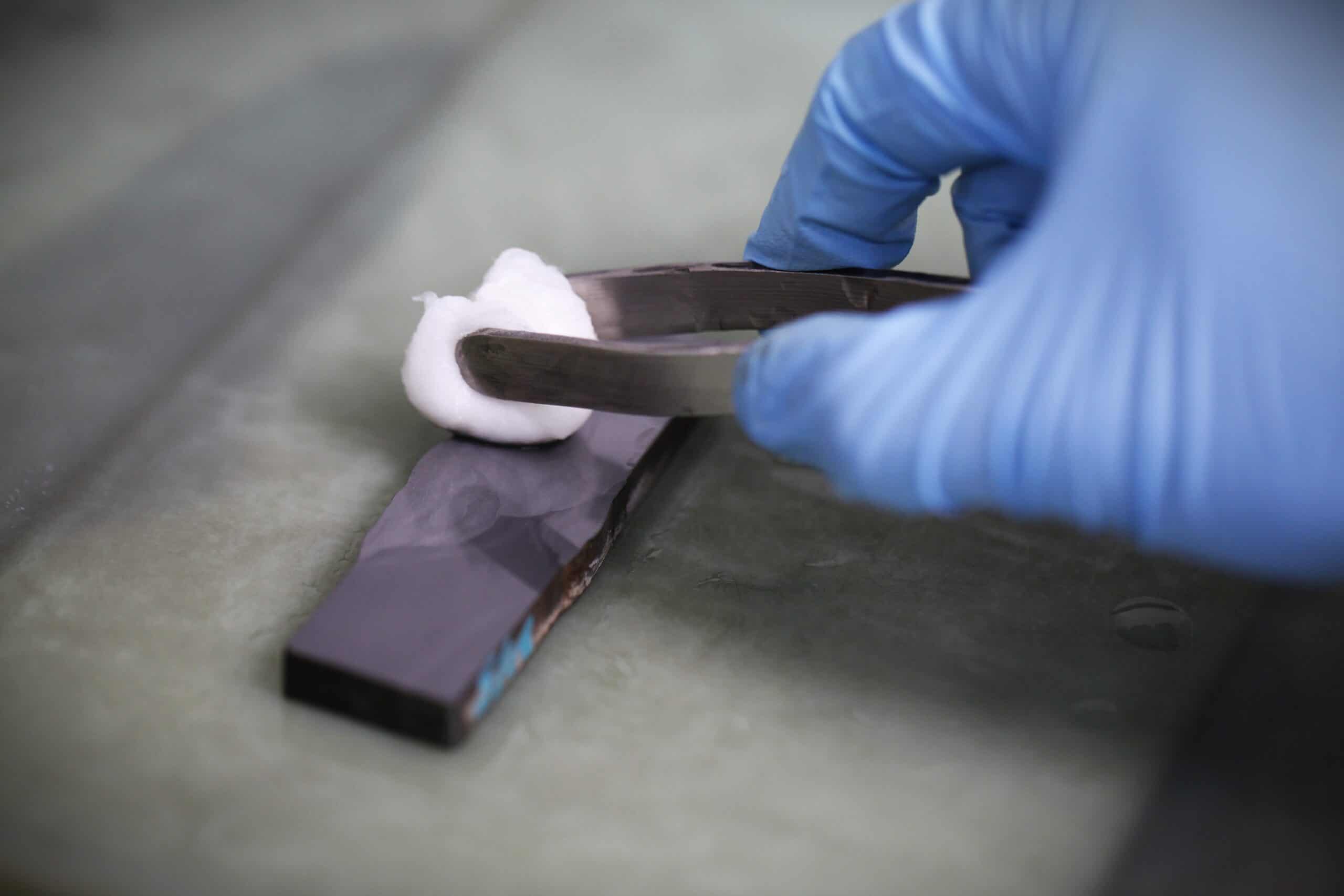 A PTS technician prepares a specimen for a macro etch weld test procedure.